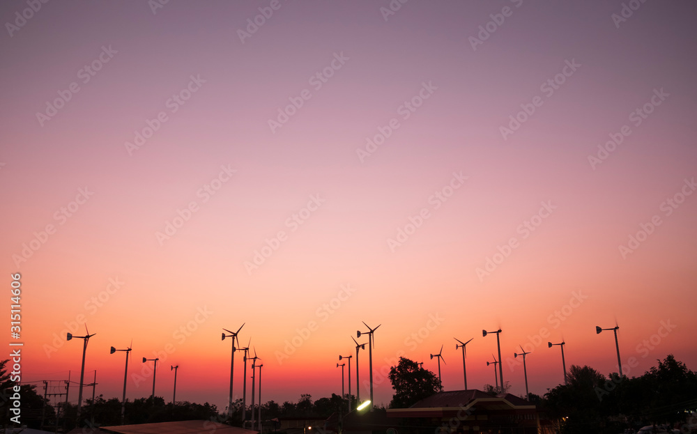 Silhouette Wind turbine spinning for electricity production during sunrise