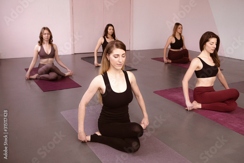 Yoga class, workout in Fitness gym background. Zen, meditation, harmony. Healthy lifestyle. Health care. Group of people meditating