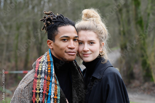 Young intercultural caucasian-hispanic student couple posing during a winter walk in Bottrop, Germany.