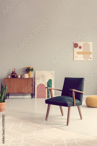 Fototapeta Naklejka Na Ścianę i Meble -  Green retro armchair in grey living room interior with wooden furniture