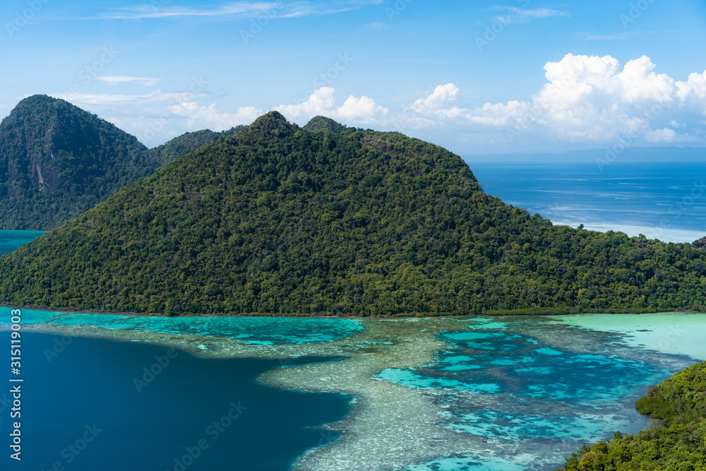 Amazing tropical paradise islands from air with blue turquoise blue lagoon water and coral reef. Aerial view of Bohey Dulang island panorama. Hawaii, Philippines, French polynesia.