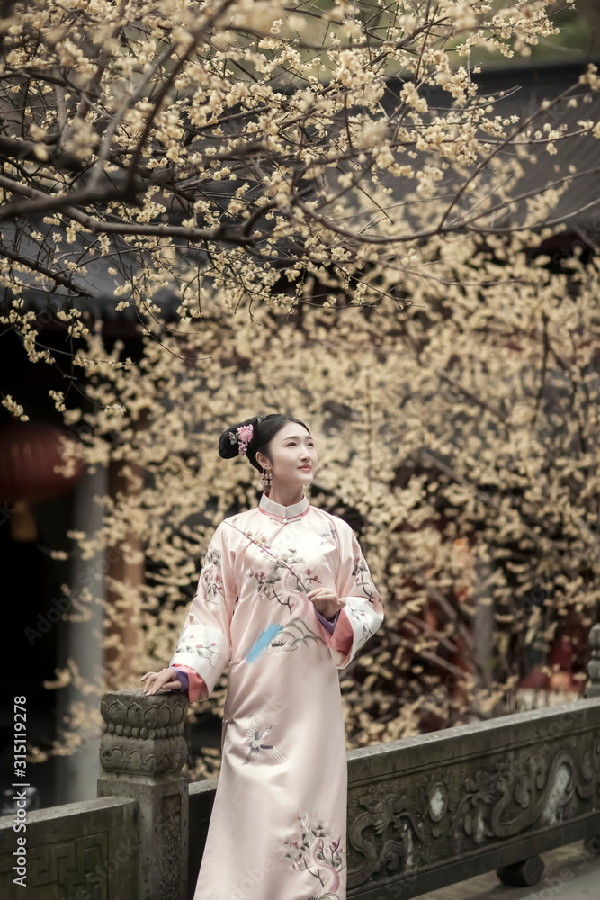 Woman in Tang Dynasty Chinese costume under a plum tree