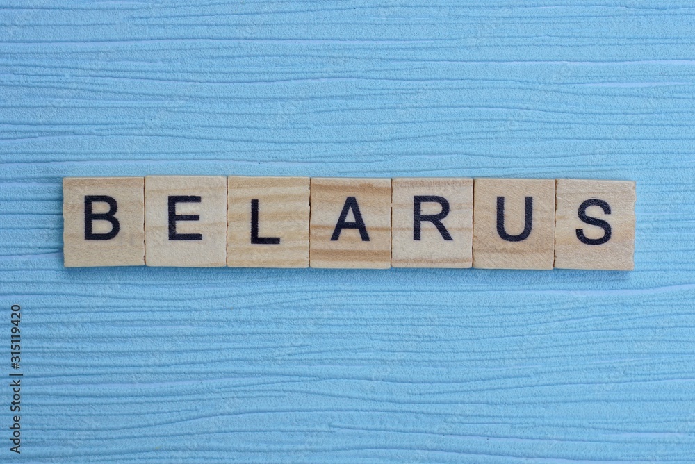 Fototapeta premium gray word belarus from small wooden letters on a blue table