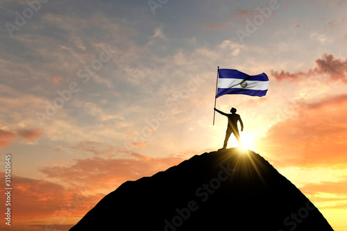 Fototapeta Naklejka Na Ścianę i Meble -  El Salvador flag being waved at the top of a mountain summit. 3D Rendering