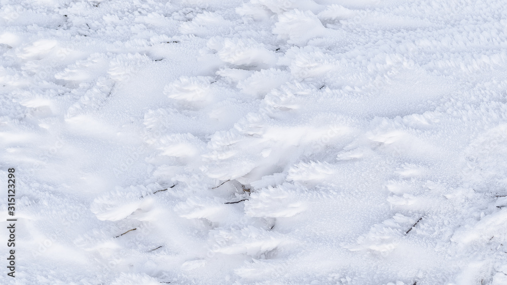 Granular snow lies on the ground. Winter background