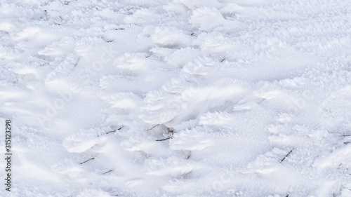 Granular snow lies on the ground. Winter background