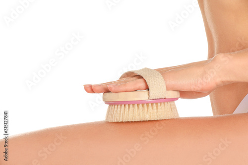 Beautiful young woman with massage brush on white background, closeup