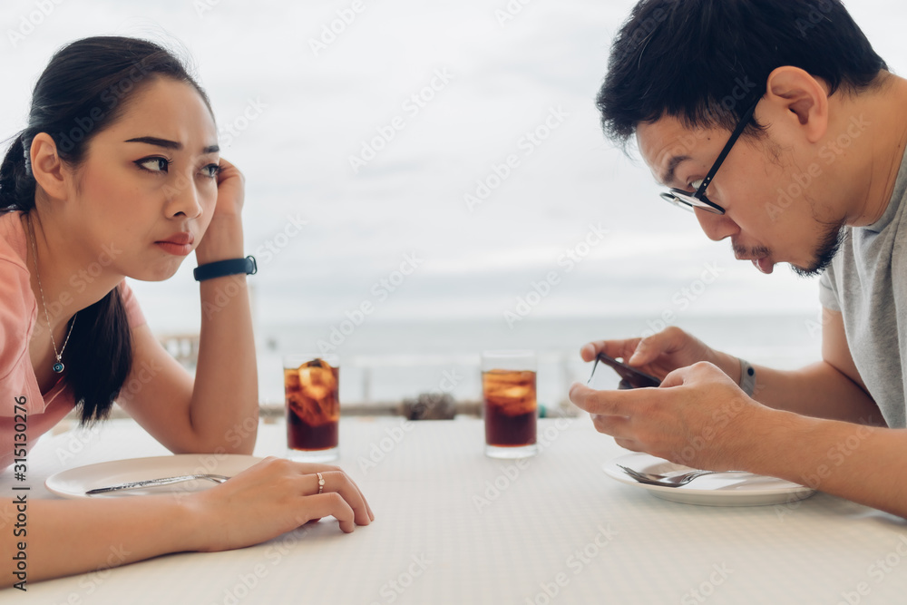 Lover couple is having a bad date at the restaurant on the beach. Lover couple is having a bad date at the restaurant on the beach.