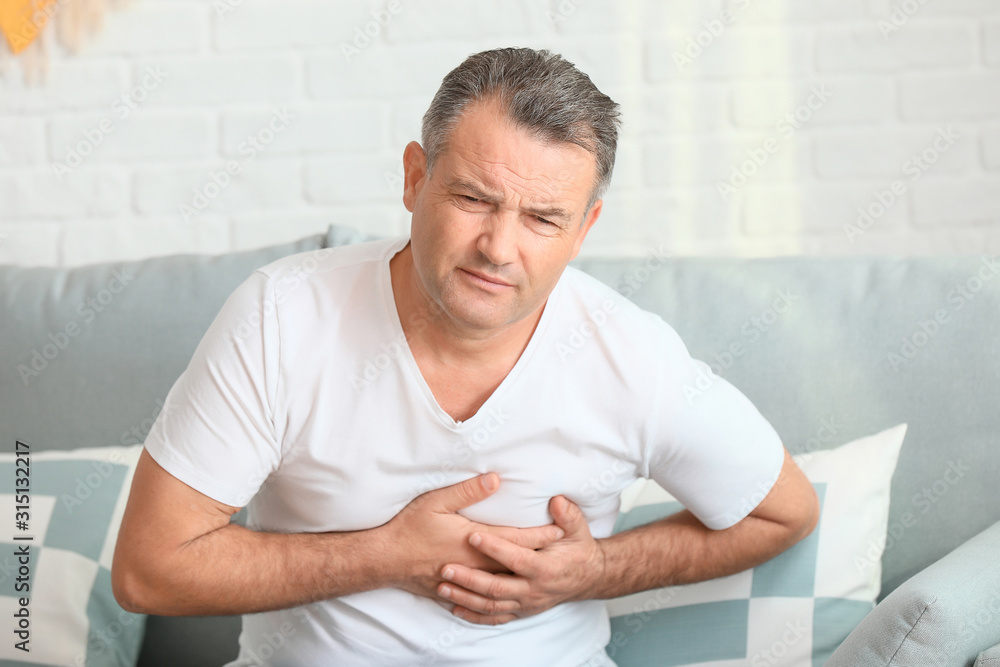 Fototapeta premium Mature man suffering from heart attack at home