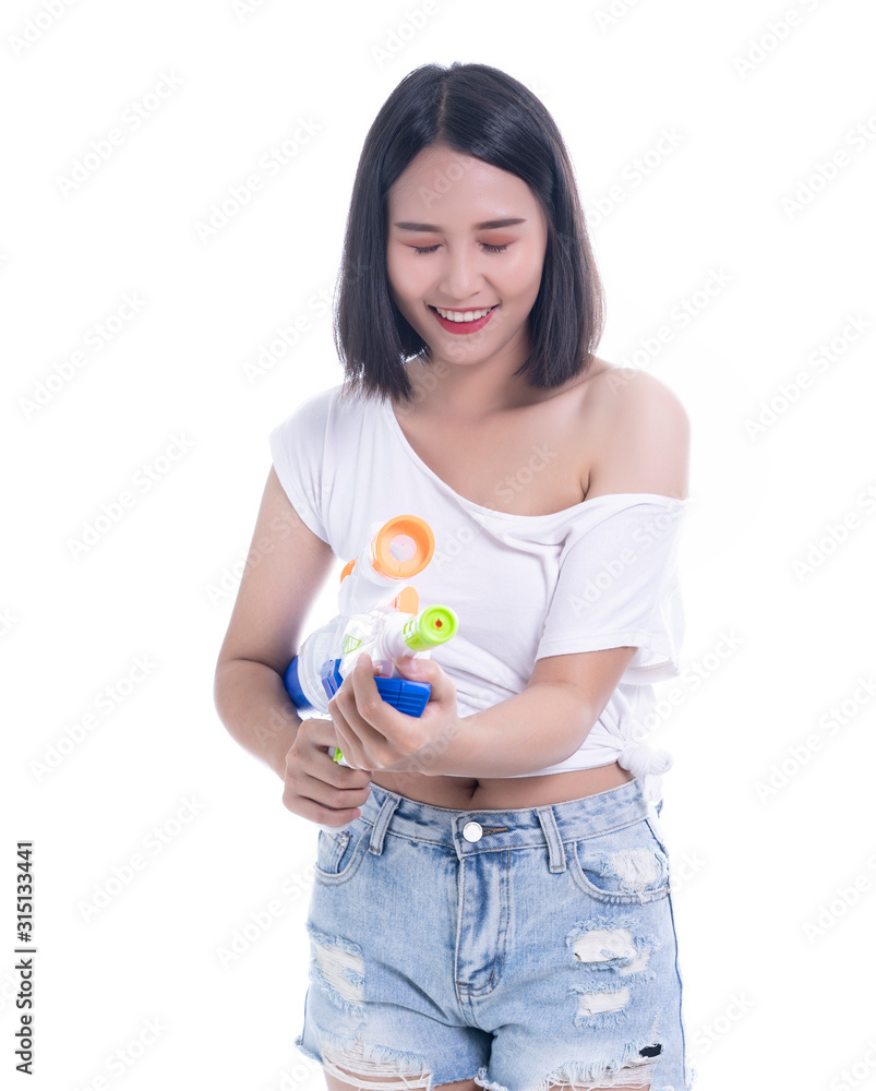 Smiling beautiful Asian girl holding plastic water gun at Songkran festival, Thailand. Modern Beauty fashion women short hair wear White t-shirt happy in Thai ceremony Isolated on white background Smiling beautiful Asian girl holding plastic water gun at Songkran festival, Thailand. Modern Beauty fashion women short hair wear White t-shirt happy in Thai ceremony Isolated on white background