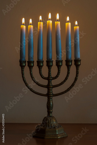 Low key Image of jewish holiday Hanukkah background with menorah traditional candelabra and burning candles