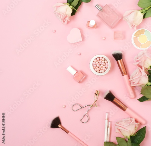 Makeup products, decorative cosmetics and pink roses on pink background flat lay , top view, copy space. Fashion and beauty concept. 