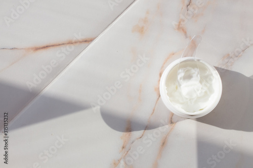 Cream in a jar on marble. Spa layout with text space. Preservation of youth, smoothing wrinkles, skin care