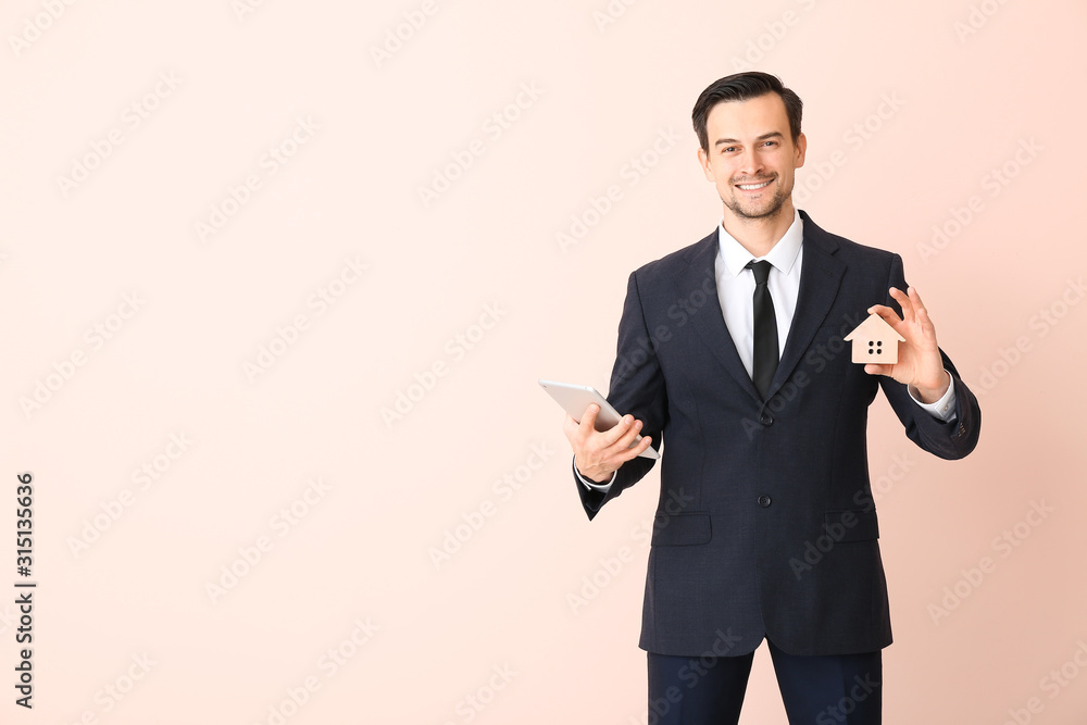 Male real estate agent with tablet computer on color background Male real estate agent with tablet computer on color background