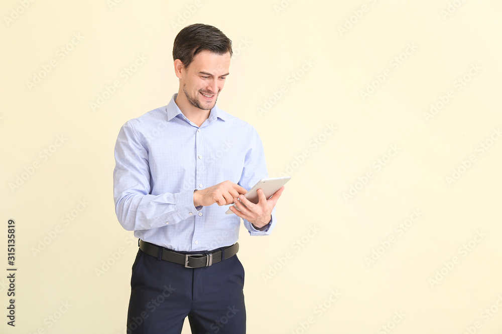 Male real estate agent with tablet computer on light background Male real estate agent with tablet computer on light background