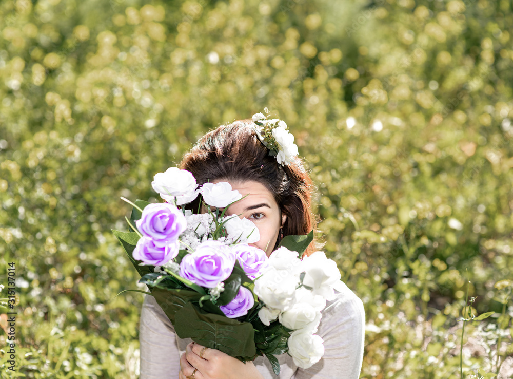 Obraz premium Chica escondida tras ramo de flores