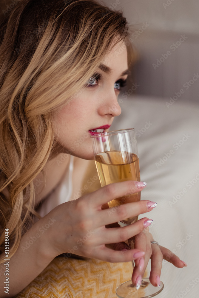 Concept morning of the bride. A beautiful gentle attractive sweet young girl in a silk white dress-combination is enjoying herself, getting ready for a date, resting and relaxing alone in the bathroom Concept morning of the bride. A beautiful gentle attractive sweet young girl in a silk white dress-combination is enjoying herself, getting ready for a date, resting and relaxing alone in the bathroom