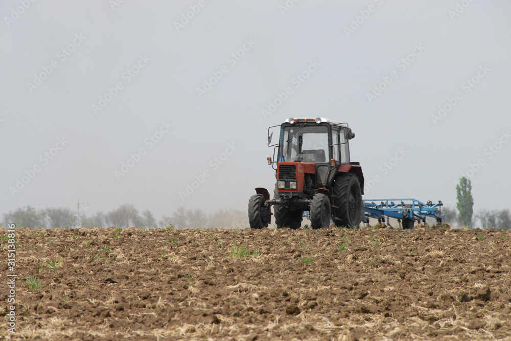 Tractor in the field plows the land Tractor in the field plows the land