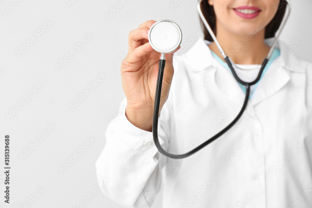 Female cardiologist on light background Female cardiologist on light background