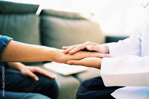 Doctor and patient shaking hands in office, they are sitting at desk, discussing something ,Having Consultation,Medical physician working in hospital writing a prescription, medically Healthcare