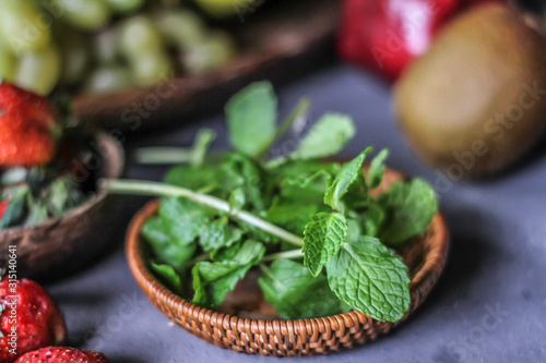 Photo of fresh mint leaves in a bowl. Mint and strawberry. Ingredients for summer cocktails and lemonade. Herb. Still life photography. Image