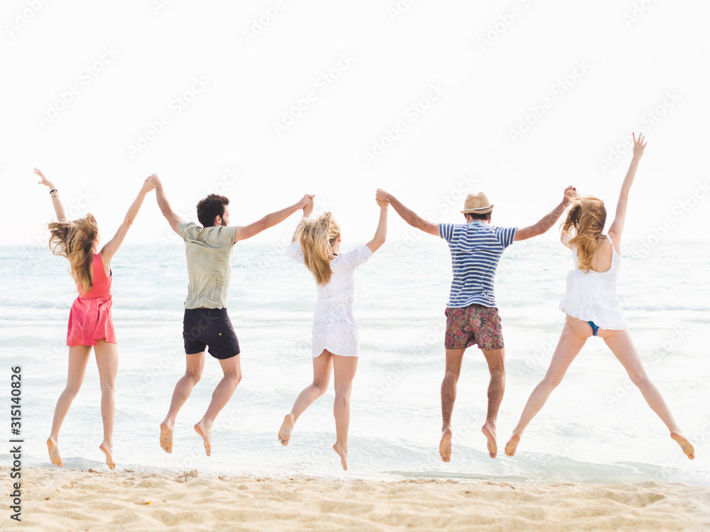 Obraz premium Group of friends jumping on the beach