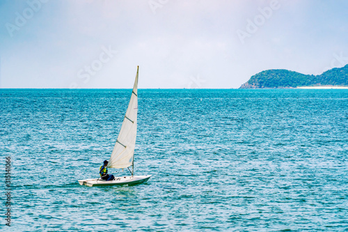 Sailboat in the sea in the sunlight over beautiful big mountains background,summer adventure, active vacation in Mediterranean sea, Sailing ship yachts with white sails in the open Sea. Luxury boats.