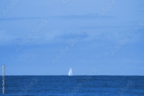 Weisses Segelschiff am Horizont