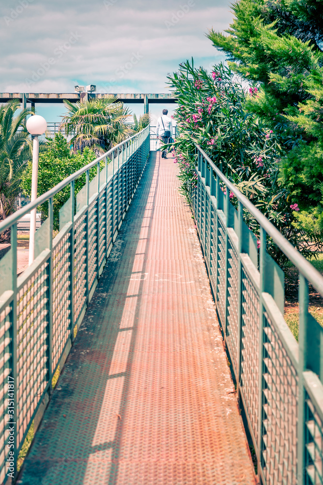 man climbing up a long bridge to reach his goal man climbing up a long bridge to reach his goal