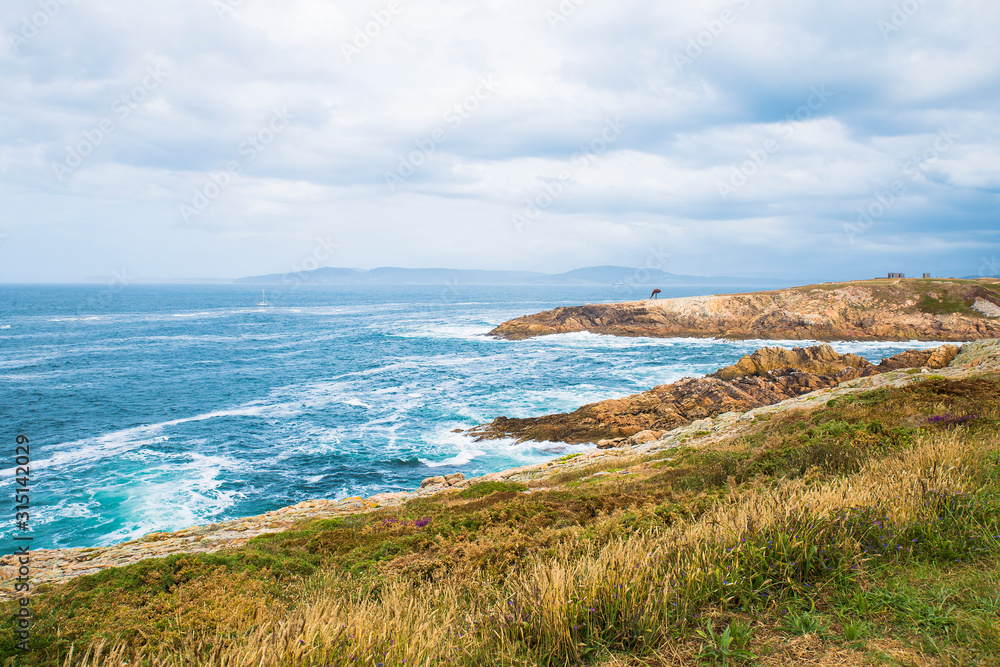 view of the Atlantic Ocean with the sculpture of the Caracola in the distance. A coruna, Spain view of the Atlantic Ocean with the sculpture of the Caracola in the distance. A coruna, Spain