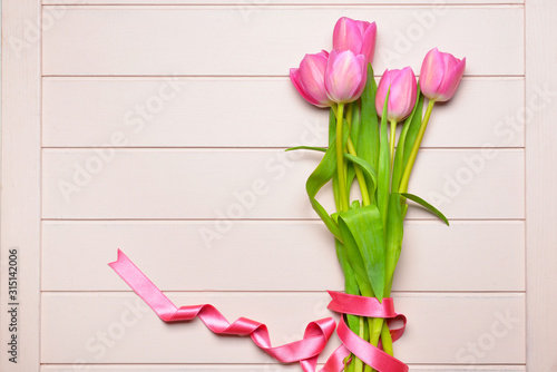 Beautiful tulip flowers on white wooden background
