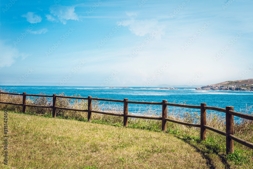 wooden fence at the top of the hill overlooking the sea in a coruna, spain