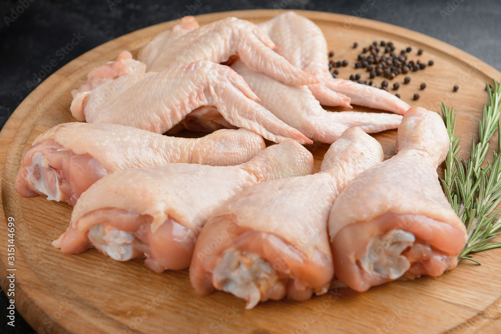 Raw chicken meat on wooden board, closeup