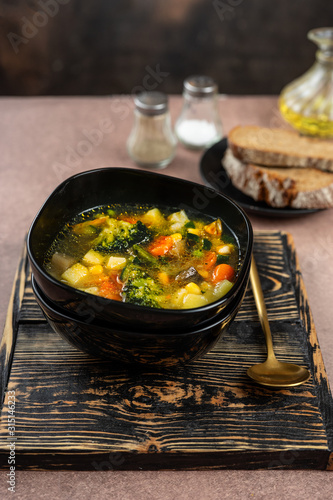 Spring vegetable soup in a black bowl
