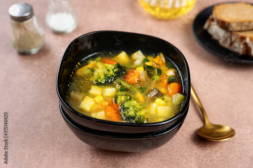 Spring vegetable soup in a black bowl