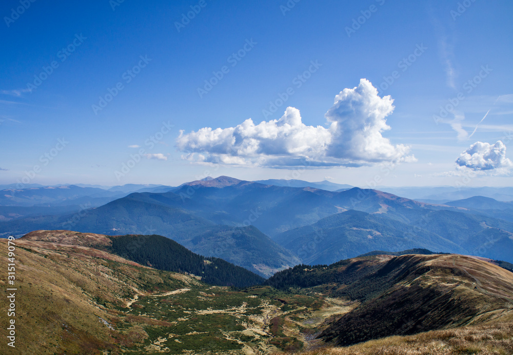 Colorful mountain landscape in the summer mountains. Large hills with blue sky.