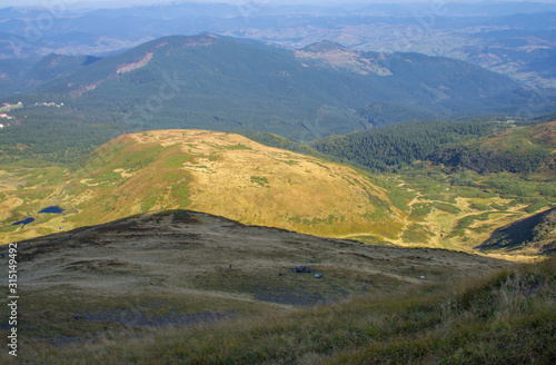 Colorful mountain landscape in the summer mountains. Large hills with blue sky.