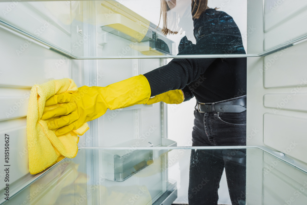 Cropped view of woman in rubber gloves cleaning refrigerator with rag isolated on white Cropped view of woman in rubber gloves cleaning refrigerator with rag isolated on white