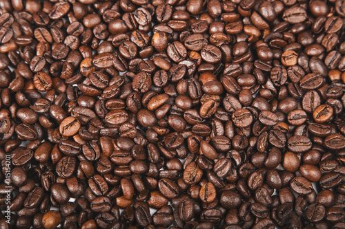 Fresh roasted brown coffee beans, top view of seeds texture as food background for design.
