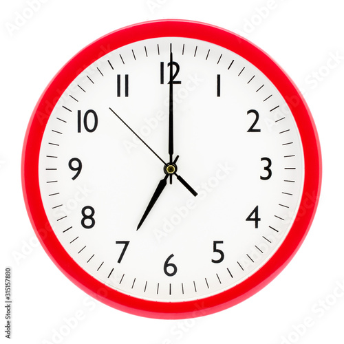 Clock with red round frame on white isolated background shows 7(19) hours 00 minutes_