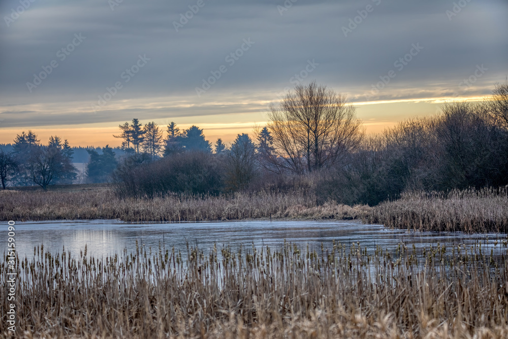 Beautiful winter rural landscape with frozen small pond. Sunrise in Czech beautiful highland vysocina european countryside
