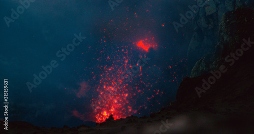 Fototapeta Naklejka Na Ścianę i Meble -  CLOSE UP: Glowing hot magma bursting out of the volcanic crater in Vanuatu.