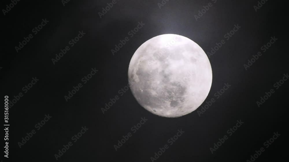 Clouds passing by moon at night. Full moon at night with clouds in real time. Clouds passing by moon at night. Full moon at night with clouds in real time.