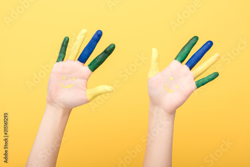 cropped view of woman with colorful fingers isolated on yellow