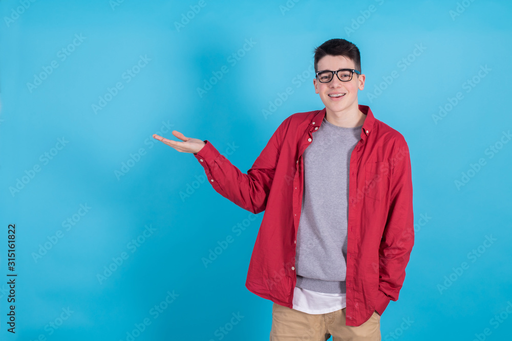 young teenage man smiling and pointing isolated on color background young teenage man smiling and pointing isolated on color background