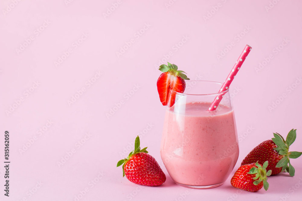Glass of fresh strawberry milkshake, smoothie and fresh strawberries on pink, white and wooden background. Healthy food and drink concept. Glass of fresh strawberry milkshake, smoothie and fresh strawberries on pink, white and wooden background. Healthy food and drink concept.