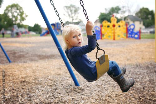 Картината върху платно Cute Little Preschool Child Swinging at Playground