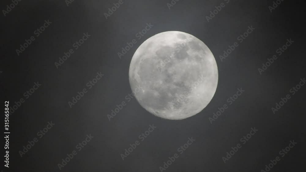 Clouds passing by moon at night. Full moon at night with clouds in real time. Clouds passing by moon at night. Full moon at night with clouds in real time.