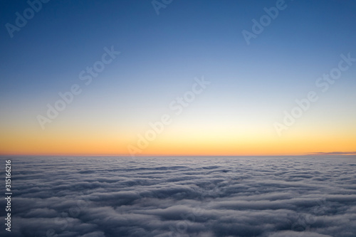 Yellow and blue dawn over clouds, concept, travel and leisure. © maykal