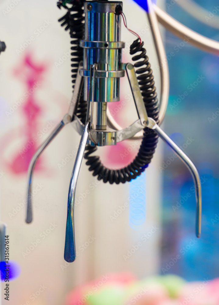 Mechanical claw game machine. Close-up view. Mechanical claw game machine. Close-up view.